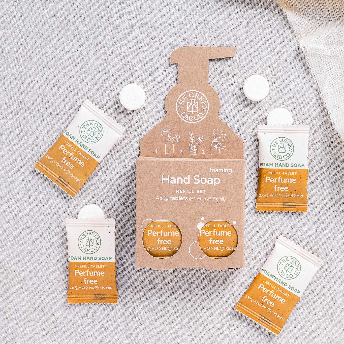 The Green Lab Co foaming hand soap refill set—perfume-free tablets on a light fabric background.